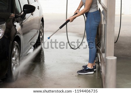 Young girl cleaning the car