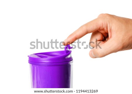 Hand closed a purple thermo mug. Close up. Isolated on white background