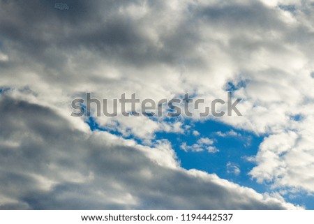 Lead rain clouds envelop the blue sky