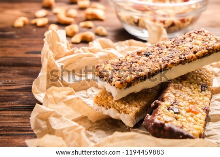 Mixed gluten free granola cereal energy bar with dried fruit & various nuts, gray concrete background. Healthy vegan super food, fitness dieting snack for sporty lifestyle. Top view, copy space.