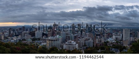 Aerial panoramic view of a beautiful modern downtown city during a striking cloudy sunrise. Taken in Mt Royal, Montreal, Quebec, Canada.
