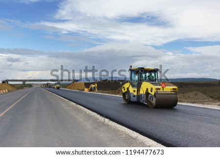 Laying the next layer of asphalt in the construction of a new road Tavrida in the Crimea. The crossing of roads is equipped with safe bridge crossings. Special machinery Royalty-Free Stock Photo #1194477673