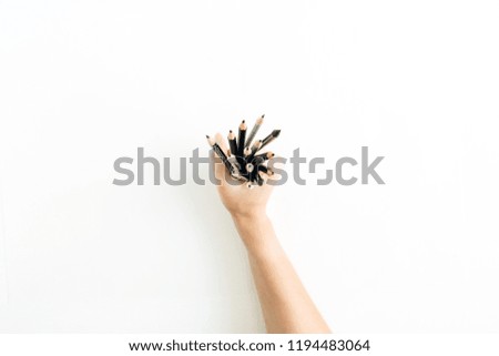 Woman hand holding bunch of pencils on white background. Flat lay, top view art concept.