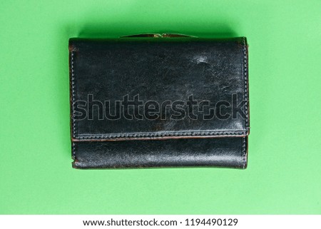 old brown leather wallet on green background