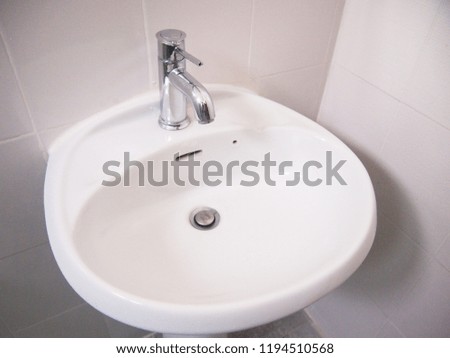 Modern silver color stainless steel tap faucet on the hygienic wash basin in the bathroom.