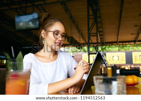 Freelancer mixed race woman hand pointing with stylus on convertible laptop screen in tent mode. Asian caucasian girl using 2 in 1 notebook with touchscreen for drawing and work on design project. Royalty-Free Stock Photo #1194512563