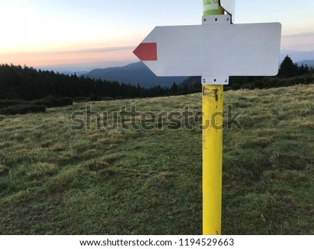 Blank wooden direction sign on a hiking trails in mountains