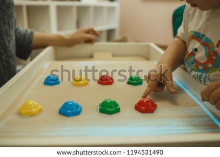 Children painting in the interactive sand box , sand animation. Educational game for toddlers.