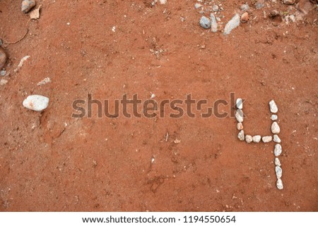 Number Four 4 Made Out of Rocks on Dirt Background powerpoint  