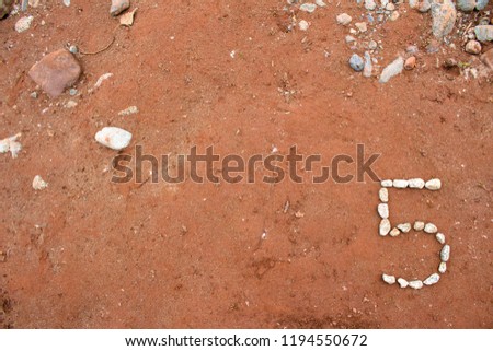 Number Five 5 Made Out of Rocks on Dirt Background powerpoint  