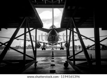 Black and white,too soft photo of Aircraft push back into the  maintenance area.Aircraft(airplane)in aircraft hangar for maintenance service check by aircraft technician.Maintenance before flight. Royalty-Free Stock Photo #1194565396