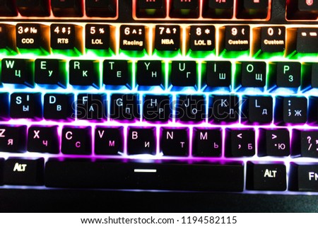 Gamer keyboard with colorful lights, modern laptop computer.