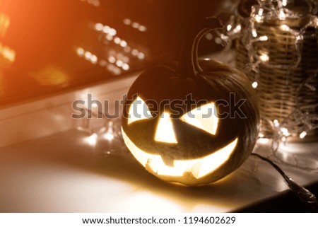 Halloween pumpkin with candle on window. Symbol of halloween.