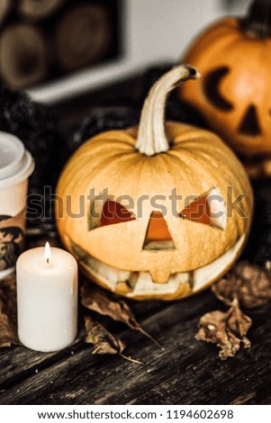 Halloween pumpkin with candle on wood background. Symbol of halloween.
