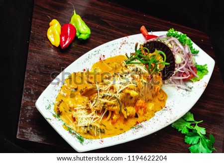 plate of sea food with salad accompanied by aji and cilantro