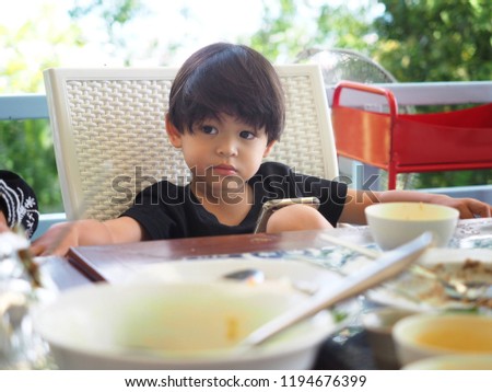 Little boy is bored with the food in front of him