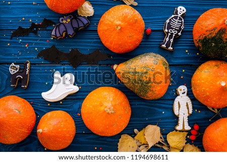 Preparing to Halloween. Pumpkins and cute figures of halloween evils. Bats, skeleton, ghosts. blue wooden background top view