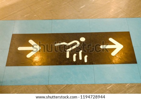 Symbols on the floor, Top view of man feet standing over Arrow symbol on subway platform, dry concrete floor on parking area.