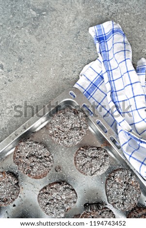 homemade chocolate muffins on a marble background - concept with chocolate muffins, baking utensils and blue dishcloth