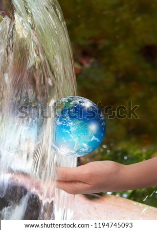 Woman holding glass globe on her hand with waterfall - drinking water crisis "Elements of this image furnished by NASA "