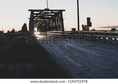 A Beautiful Old Bridge at Sunset with a Car Crossing
