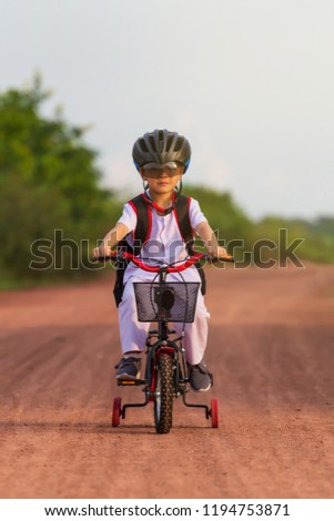 Happy boy with his bike.Kid learns to ride a bicycle on the road.