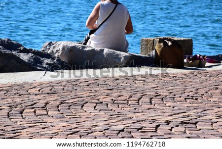 Woman sitting at the shore, Italy