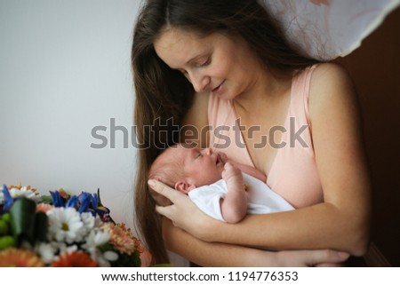 sweet newborn baby sleeps on the gentle hands of mom, lifestyle and real interior