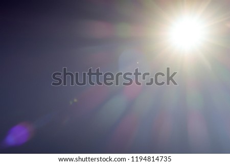 Nature Sun light radiation of lens fare with spectrum for background, backdrop, template & wallpaper. The bright sun shines on a blue sky background, Copy space.  Realistic sun burst with flare. Royalty-Free Stock Photo #1194814735