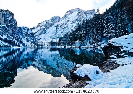 snowy dolomites in the blue sky loom over the braies lake
