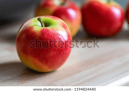 a red yellow apple, laterally in the picture, in the background more apples
