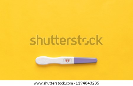 Pregnancy test on a yellow background. Close-up. There is free space.