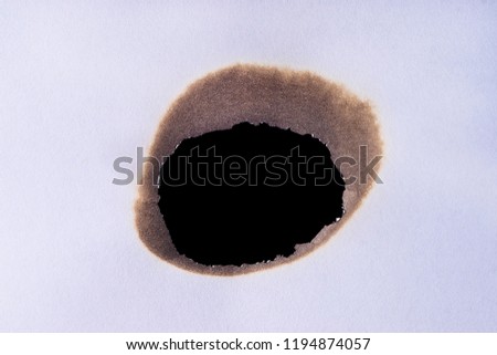 black burned hole in paper
