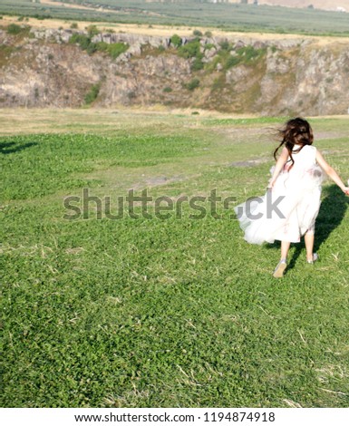 Beautiful little girl in a white dress during a wedding party in the park.Cute kid playing during open air wedding party in Saghmosavanq.Armenia Royalty-Free Stock Photo #1194874918