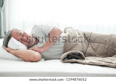 Senior man sleeping in bed. Old asian man sleeping comfortably in bed with curtain open. Senior lifesyle concept. Royalty-Free Stock Photo #1194876052