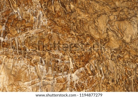 nice natural cave with fox-coloured walls and formations of stalagmites within, natural texture image.