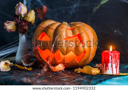Halloween picture of table with pumpkin, burning candle,