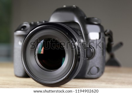 Digital camera of professional photographer on table
