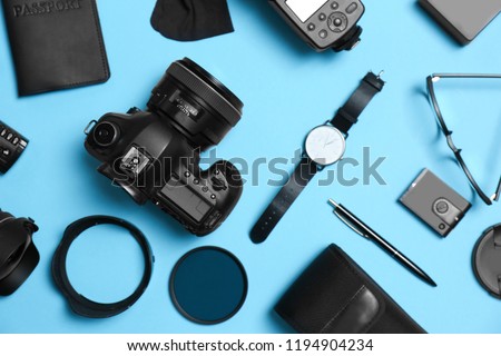 Flat lay composition with professional photographer equipment and accessories on color background