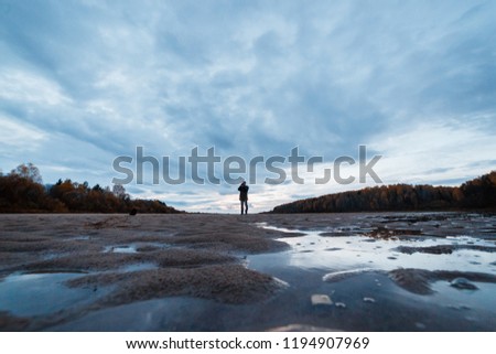 Amateur landscape photographer shooting the evening autumn scenery of the river. Landscape therapy concept.