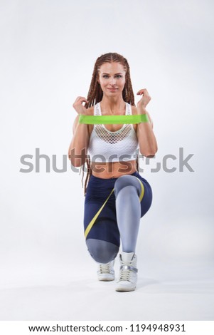 Muscular young fit sports woman athlete. Workout with bands or expander in gym. Copy space for fitness nutrition ads.