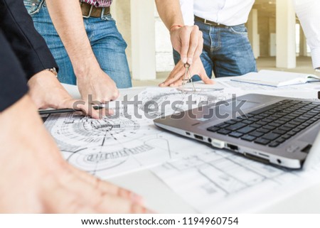 male engineers, architects working at the desk in helmets. Drawings, laptop, roulette on the desktop. Reception and supervision of building construction