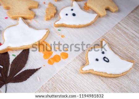 Fresh homemade decorating halloween dessert with ghost, creeping spider, bat, haunted castle and horrifying eyeball on wooden background, copy space