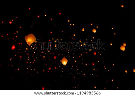 Fairy illuminated paper lanterns flying in a black sky
