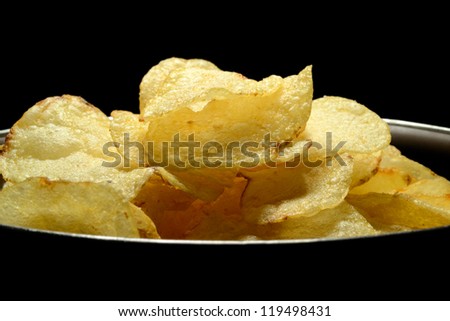 Potato chips in a snack  bowl on black background