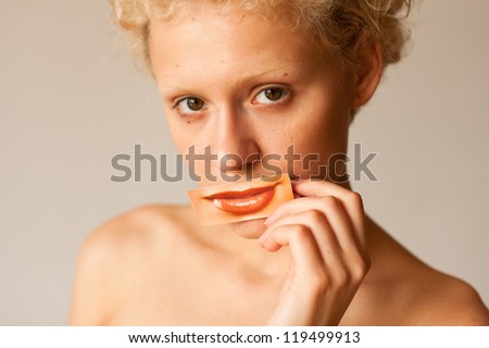 Conceptual image about plastic surgery lips - beautiful young girl closes her lips painted a picture with lips.
