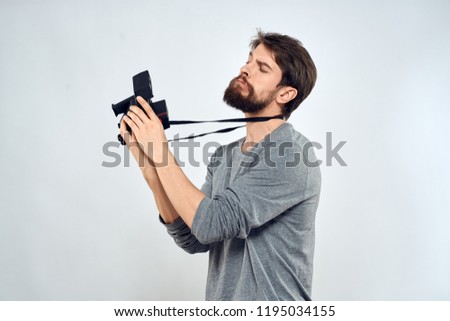 photographer in a gray jacket holds a camera in his hand                   