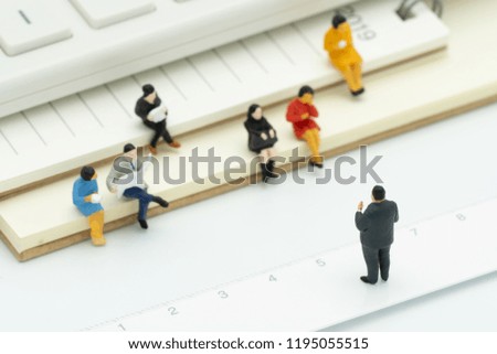 Miniature people sitting on Note Book placed white background. meeting or Discussion using as background business concept with copy space and white space for your text or  design.