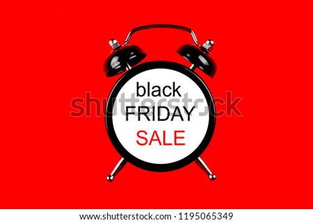 Black friday sale concept. Fourth Friday of November, beginning of Christmas shopping season since 1952. Old alarm clock with text on bright red background. Copy space, close up, top view, flat lay.