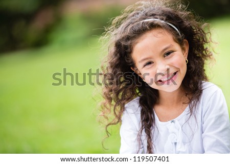 Sweet little girl outdoors with curly hair in the wind Royalty-Free Stock Photo #119507401